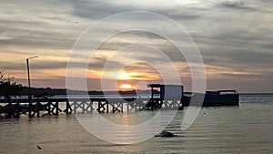 The sun sets behind Biaro Island, photo taken from the beach in Karango Biaro village, North Sulawesi photo