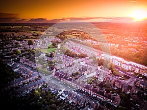 Sun setting with atmospheric effect over traditional British houses and tree lined streets.