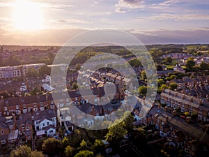 Sun setting with atmospheric effect over traditional British houses and tree lined streets.