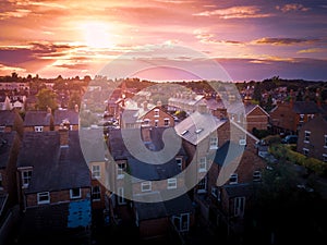 Sun setting with atmospheric effect over traditional British houses and tree lined streets.