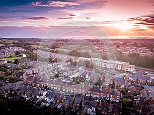 Sun setting with atmospheric effect over traditional British houses and tree lined streets.