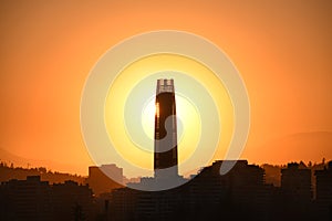 Sun setting behind a skyscraper in Santiago