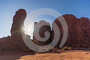 Sun setting behind the thumb rock formation at Monument Valley