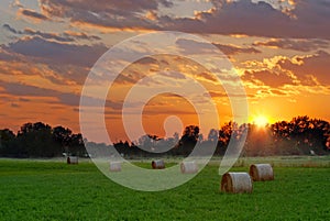 Sun setting on hay field