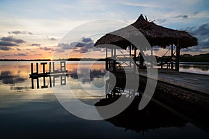 Sun setting at the lagoon behind Utila sign and dock, Utila, Honduras, Central America