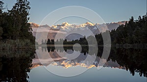 Sun setting on mt cook reflected in lake matheson