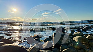 the sun is setting over the stone beach the reflections Pacific Ocean is very quiet and calm there are no waves relaxing