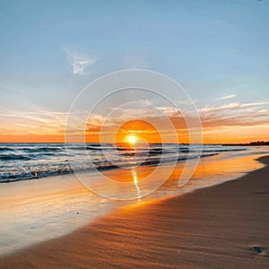 the sun is setting over the water on the beach Colorful photo