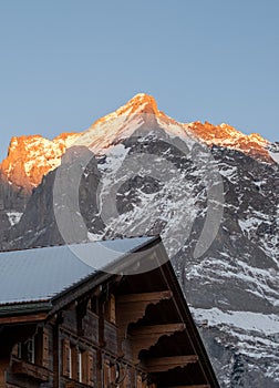 The sun setting over the Wetterhorn mountain behind the Alpine village of Grindelwald, Switzerland.