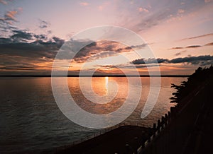 Sun setting and reflecting in the sea water of  Pegwell Bay, Kent uk