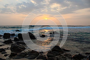 The sun setting into the sea at Delawella beach, Sri Lanka. Golden light