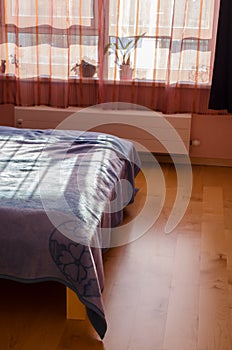 Sun shade reflected through curtains on bedspreads