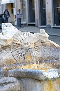 Sun-shaped human face on Fountain of the Boat Fontana della Barcaccia, next to 18th century Spanish Steps in Piazza di Spagna