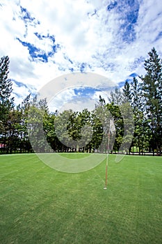 Sun shines behind a golf flag