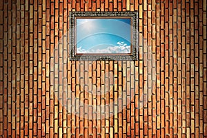 sun shines on blue sky with clouds in wooden frame on brick wall