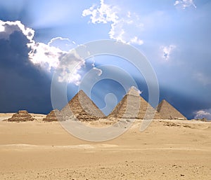 Sun shines from clouds above the Giza pyramid complex