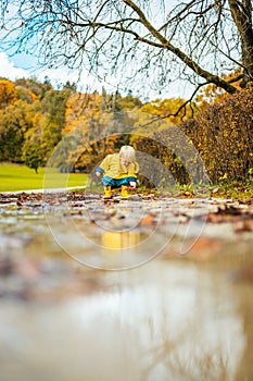 Sun always shines after the rain. Small bond infant boy wearing yellow rubber boots and yellow waterproof raincoat