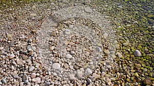 Sun shines to small gravel stones at Limni beach in Corfu, Greece - sea is crystal clear here