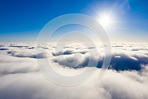Sun shining above white clouds. Aerial cloudscape