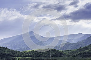 The sun shining through the clouds to the trees on the mountain at Suan phueng of Ratchaburi in Thailand