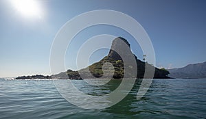 Sun shining on Mokolii island [also known as Chinamans Hat] as seen from the water on the North Shore of Oahu Hawaii United States
