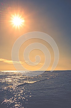 Sun shining over sea seen from LLansteffan beach with clear blue water in southern Wales