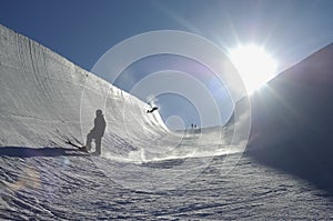 Sun Shining On People Snowboarding In Park