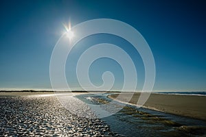 Sun is slowly setting along the Schiermonnikoog summer coastline Netherlands