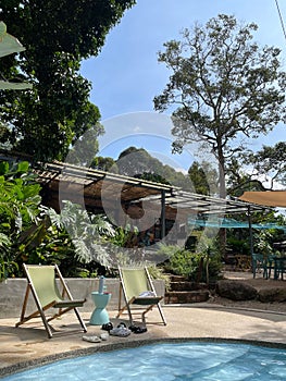 Sun-soaked outdoor patio with lounge chairs in front of a sparkling blue swimming pool