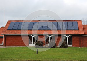 Sun Solar Panel Cell on Roof of Red House