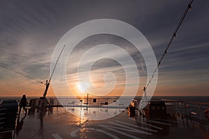 Sun about to set, seen from deck in the stern of a cruise ship