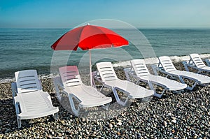 Sun umbrella and beach beds on the shingle beach