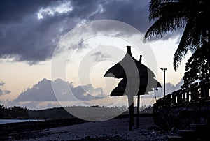 Sun umbrella and beach beds on tropical coastline, in Mauritius