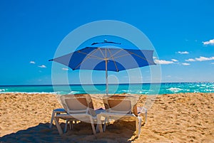 Sun umbrella and beach beds on tropical sandy beach, Tropical destinations. Cancun, Mexico. Mexico