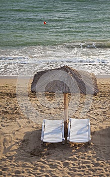 Sun umbrella on empty beach in a morning day