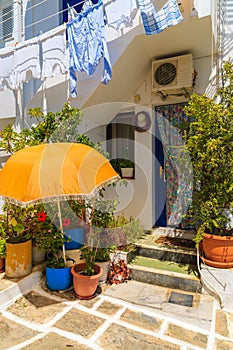 Sun umbrella and flower pots in front of a Greek typical house in Naoussa town on Paros island, Greece