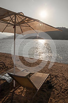 A sun umbrella and lounges at sea shore