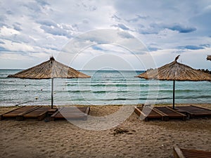 Sun umbrellas on the beach, sea water, golden sand