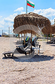 Sun umbrellas and chaise lounges on tropical beach. Concept of rest, relaxation, holidays, resort