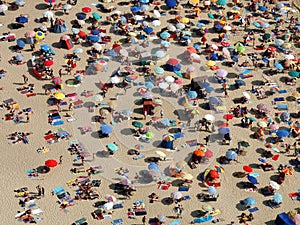 Sun umbrellas on a crowded beach photo