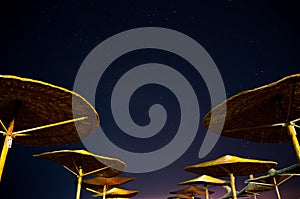 Sun umbrellas during starry night in Vama Veche beach