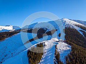 Slnko a zimné svahy v lyžiarskom stredisku. Letecký pohľad