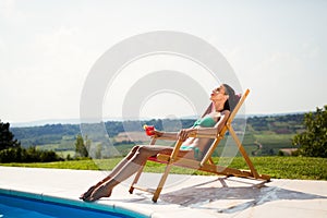 Sunbathing woman enjoying cocktail