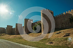 Sunbeam above the large city wall and green lawn at Avila