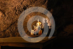 Sunbeam on Buddha statue in cave, Thailand