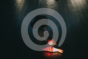 Sunbeam enlightens little boy sitting on the floor