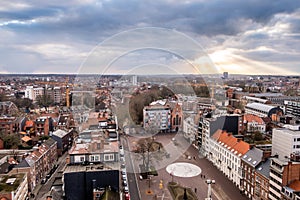 Sunbeams breaking through the cloud deck, with a panorama of Leuven, Flanders, Belgium.