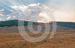 Sunbeams and sunrays through sunset clouds in the Hayden Valley in Yellowstone National Park in Wyoming