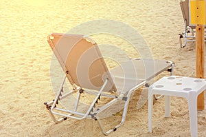 Sunbed close on beach background with burning sun