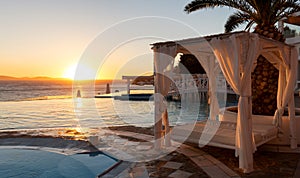 Sunbed and infinity pool at sunset